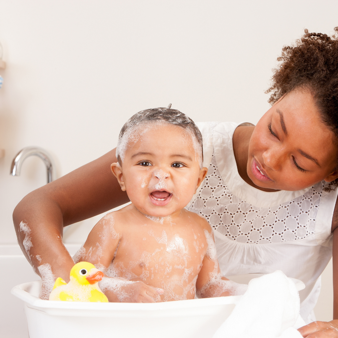 baby in bath with adult supporting